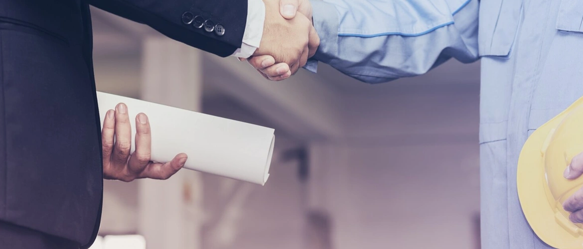 فريق استشارات هندسية يناقش بنود عقد مشروع إنشائي ويقوم بمراجعة الالتزامات والمسؤوليات لضمان تنفيذ الأعمال بجودة عالية وتقليل النزاعات بين الأطراف.